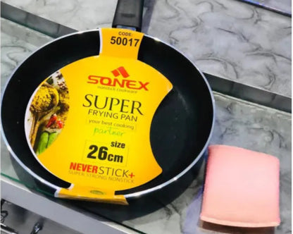 Black frying pan with a yellow Sonex label on a marble surface