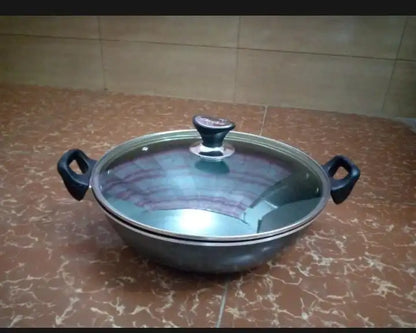 Black ceramic pot with a glass lid on a tiled floor