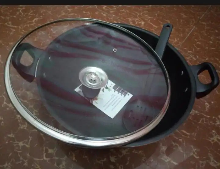 Black pot with a glass lid on a marbled surface