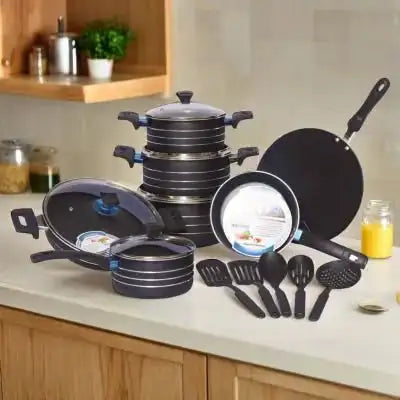Set of black cookware including pots, pans, and utensils on a kitchen counter.