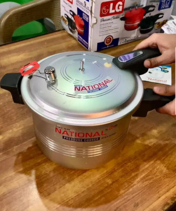 National pressure cooker on a wooden surface with an LG product box in the background.